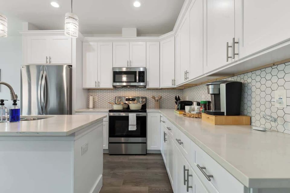 Bright, new kitchen featuring stainless steel appliances, a coffee station, and plenty of space to prepare your favorite meals.