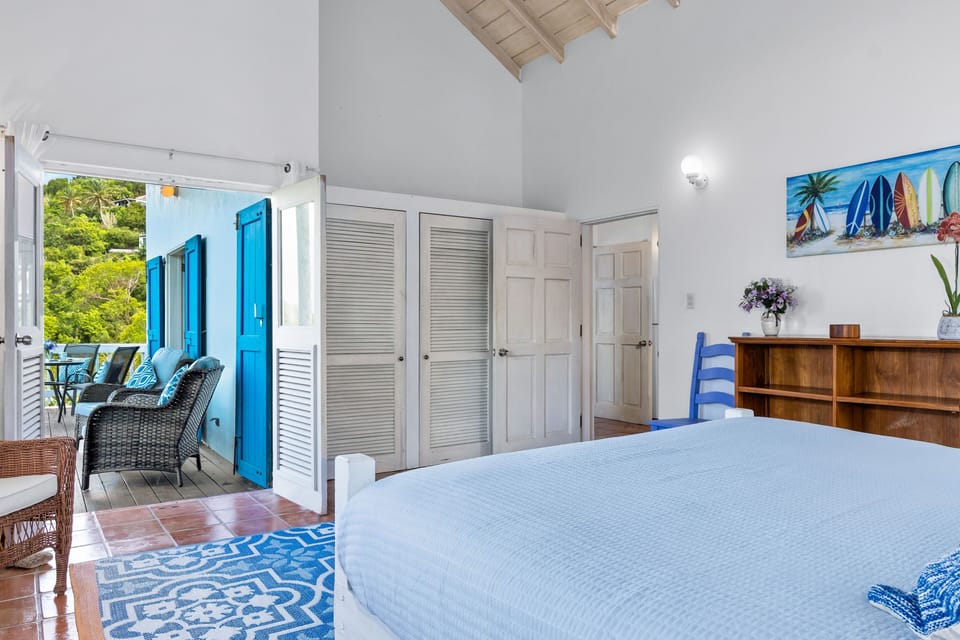 Makere Cottage master bedroom with doors to deck and kitchen/bathroom.