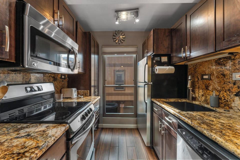 Your gourmet galley kitchen features granite countertops, stainless steel appliances, and rich wood cabinetry for memorable meal preparation.