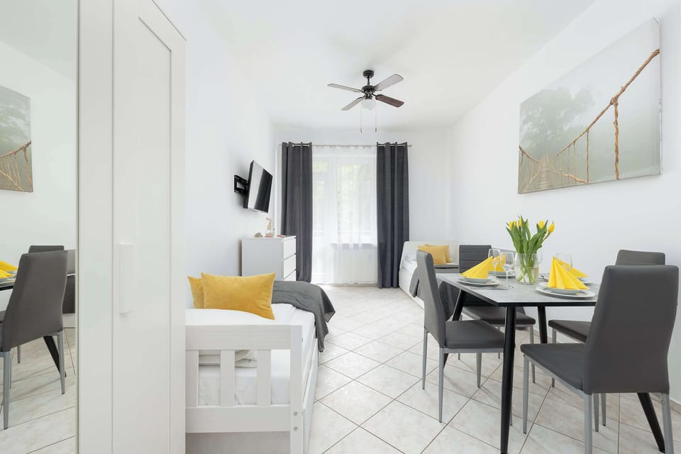 Beautifully arranged lounge area with a soft grey single beds, decorative cushions, and warm yellow accents creating a homely atmosphere.