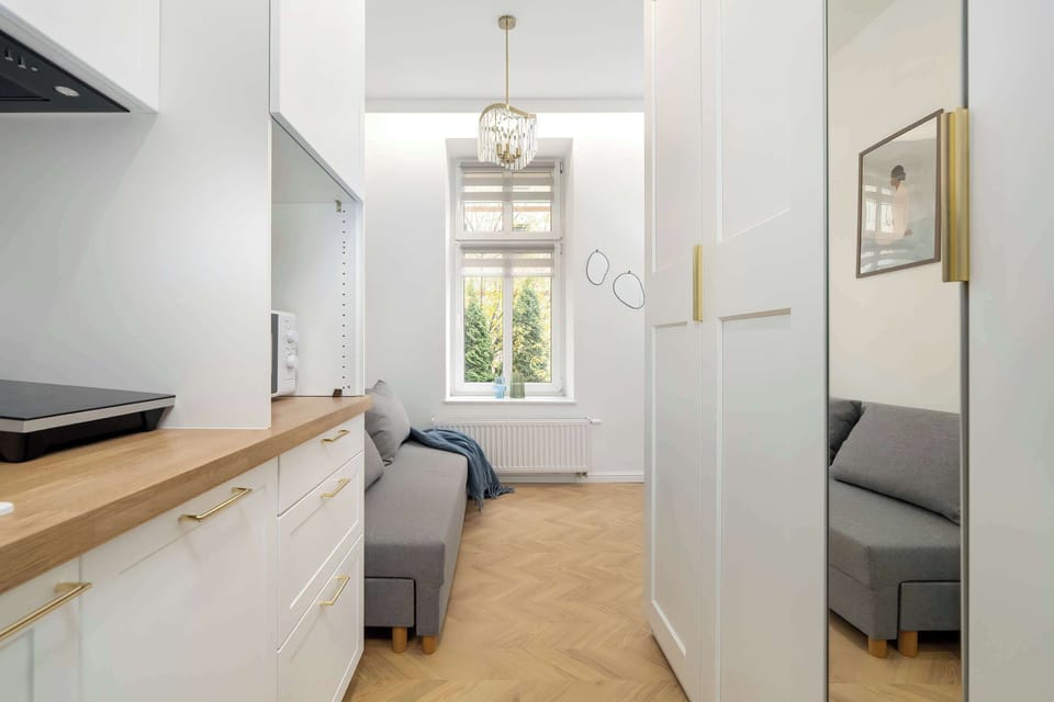 A narrow hallway leading into the main living space. Wooden flooring and light walls create a clean and welcoming atmosphere.