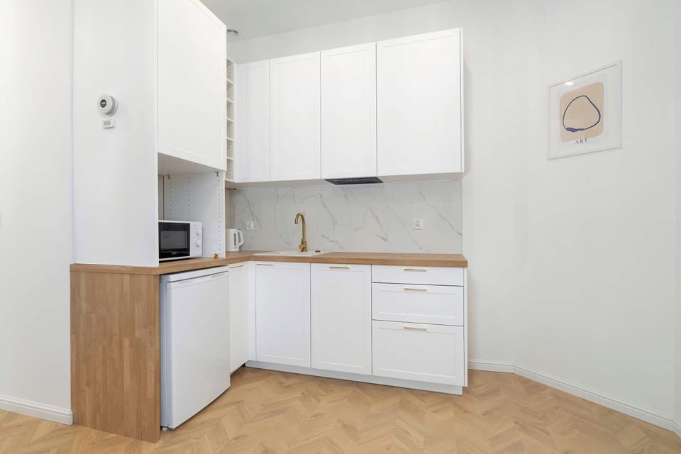 A spacious kitchen area with sleek cabinetry and a small dining setup. The layout is open and designed for functionality.