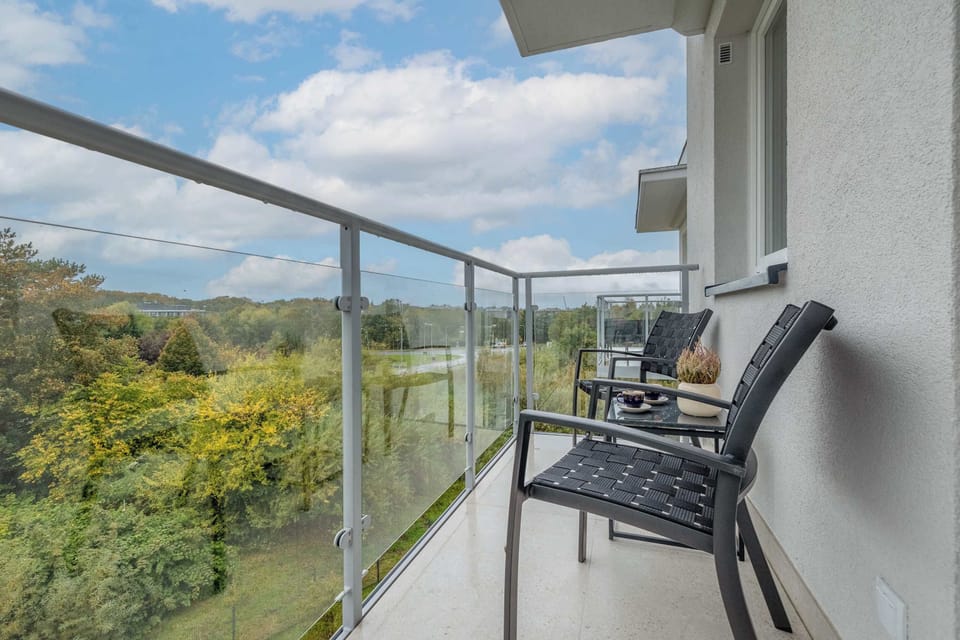 Balcony equipped with a small table and chairs, offering a peaceful view over the greenery — perfect for a morning coffee.