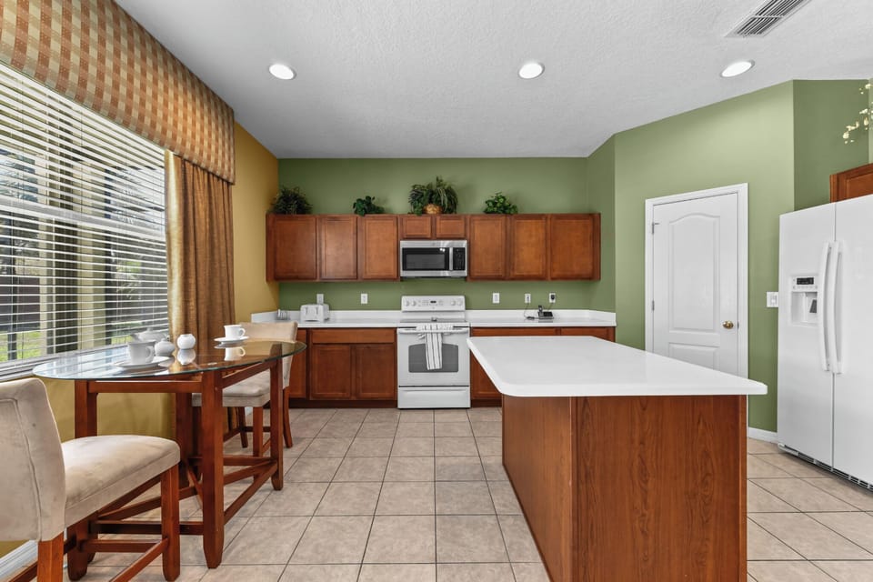 KITCHEN:  Eat-In-Kitchen with 2-Seat Dining Table and Direct Access to Patio/Pool Area 