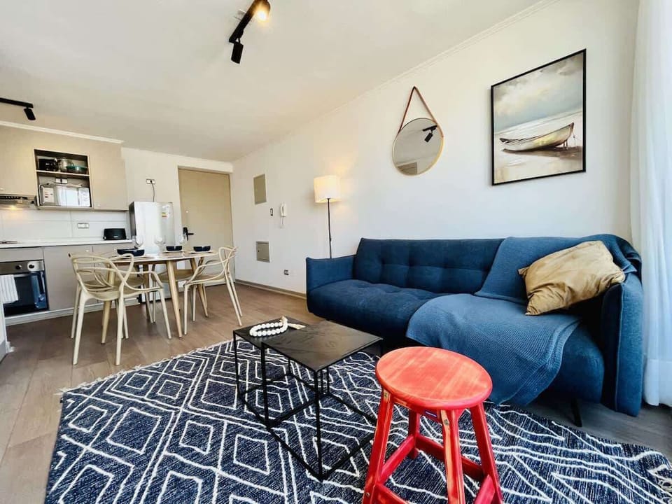 Bright living & dining area w/ blue sofa, breakfast bar & modern decor