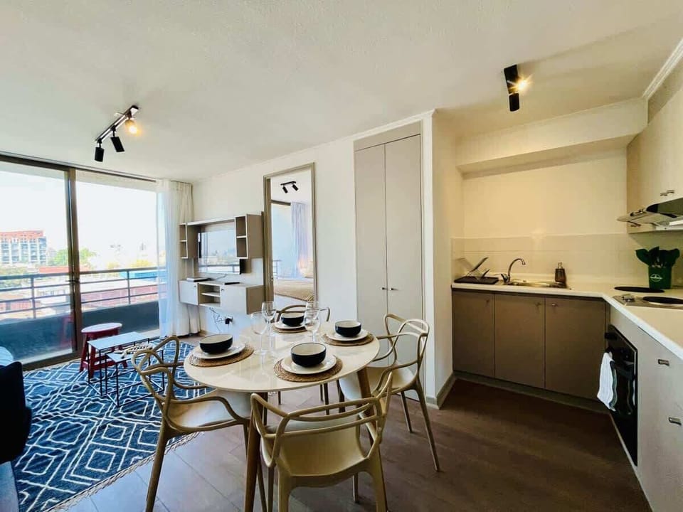 Cozy dining space set for a meal beside a sleek open kitchen