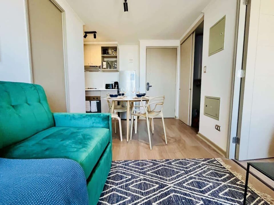 Welcoming living area w/ green sofa & patterned rug for added charm