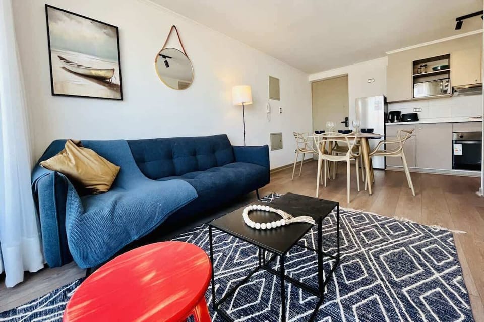 Bright living room w/ blue sofa & patterned rug for relaxed evenings in