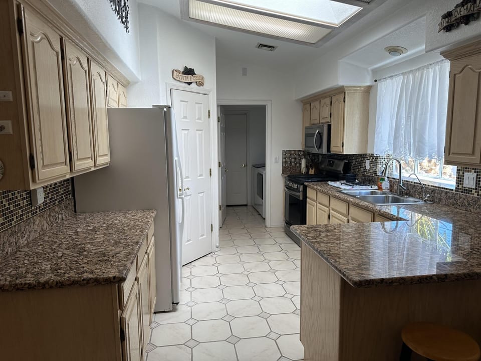 Bright, spacious kitchen with granite countertops and natural light