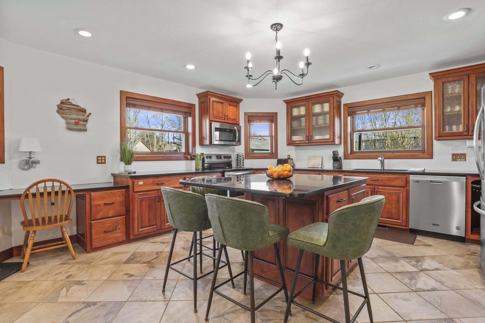 Fully stocked kitchen with 4 barstools at the breakfast bar, complimentary coffee and tea station, and visibility to the living room and back yard.