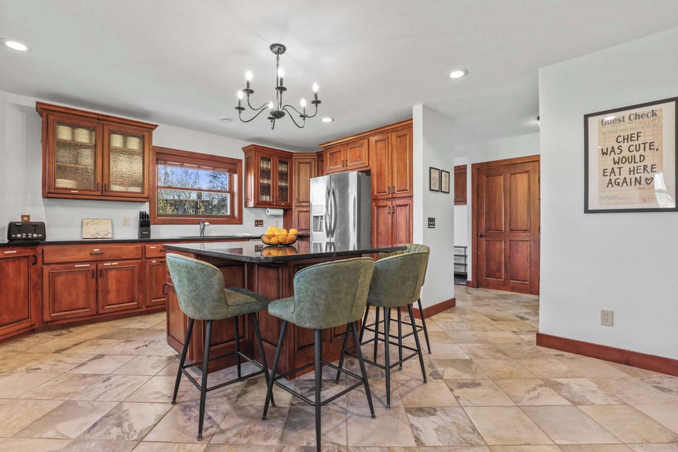 Fully stocked kitchen with 4 barstools at the breakfast bar, complimentary coffee and tea station, and visibility to the living room and back yard.