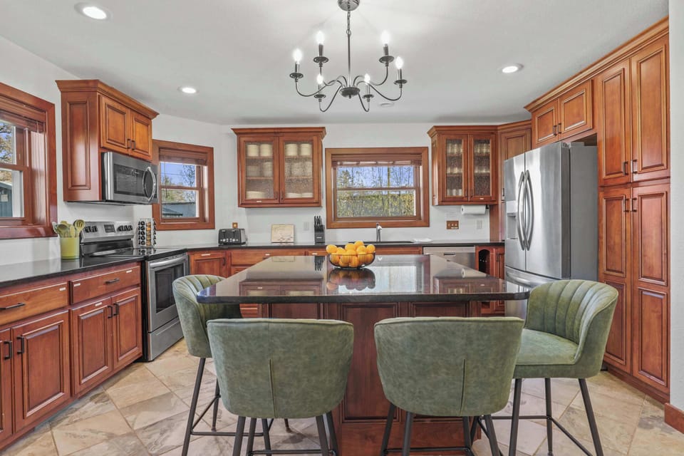 Fully stocked kitchen with 4 barstools at the breakfast bar, complimentary coffee and tea station, and visibility to the living room and back yard.