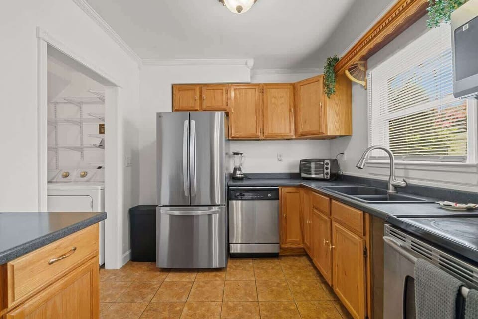 Fully equipped kitchen featuring stainless steel appliances, wooden cabinets, and all your cooking essentials.