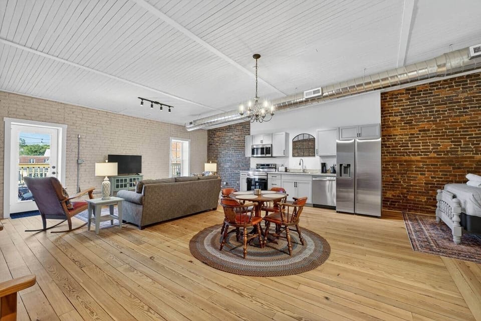 Dine with family and friends around this antique table and chairs on a braided rug under a dimmable chandelier.