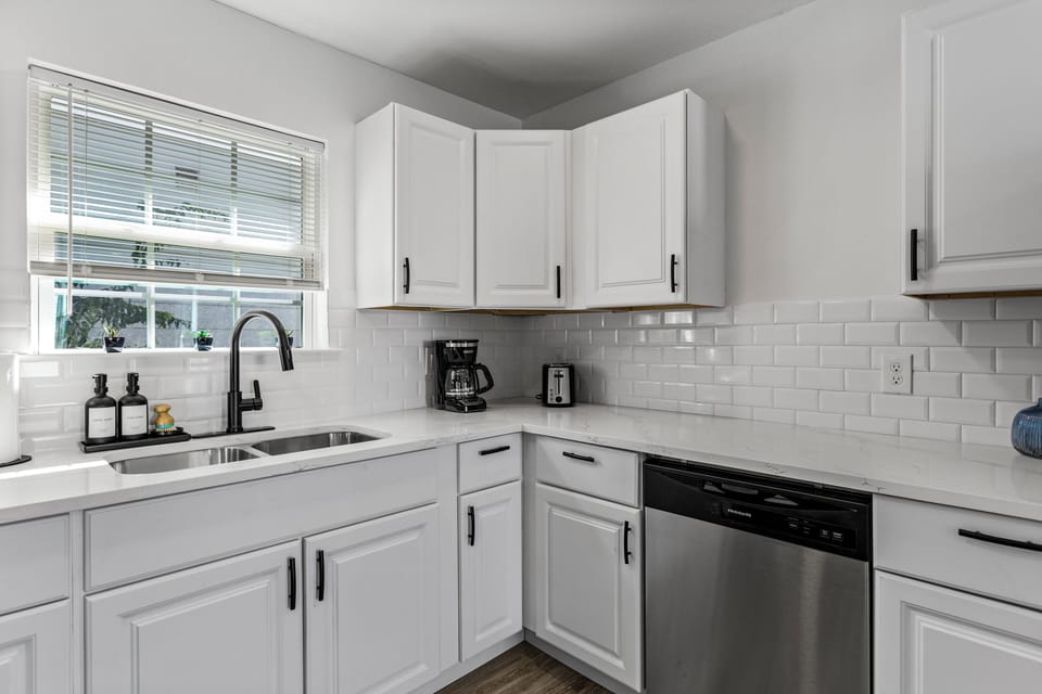 Bright kitchen with stainless steel appliances, coffee maker and toaster