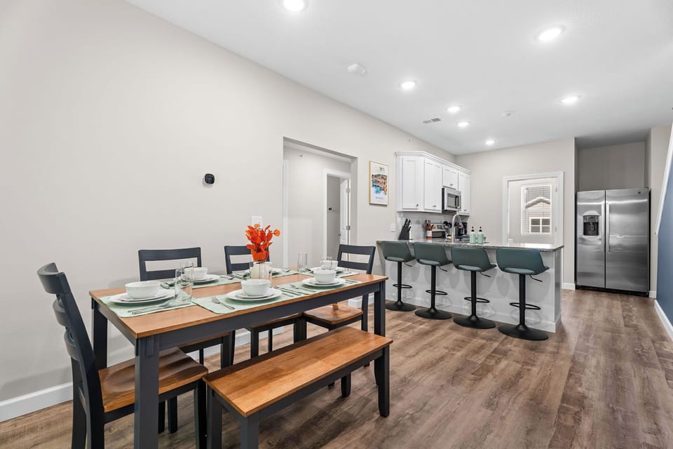 The dining table seats 6 comfortably with 4 more adjustable bar stools close by.