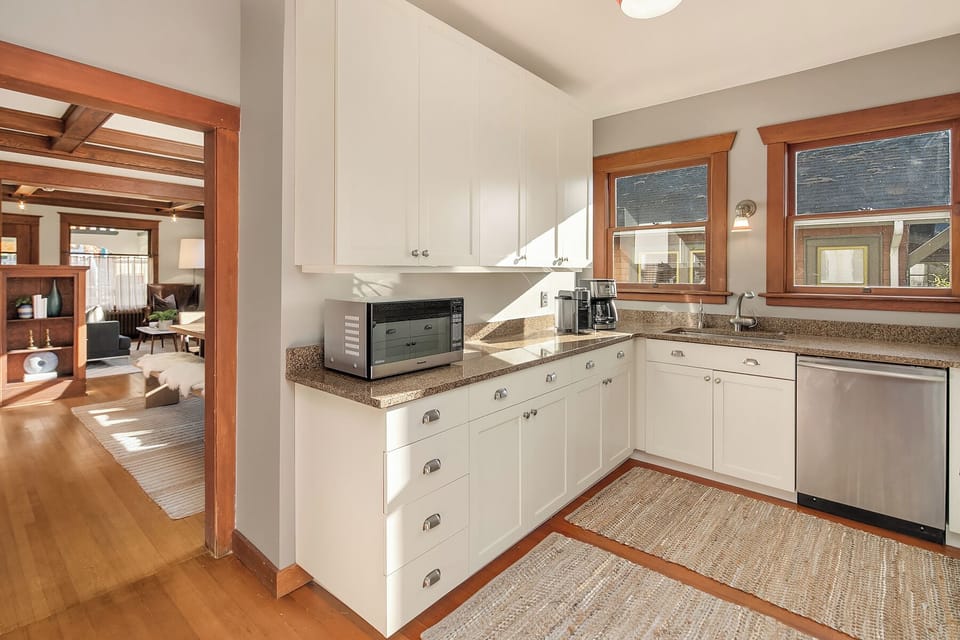 Bright kitchen with marble counters and stainless appliances.