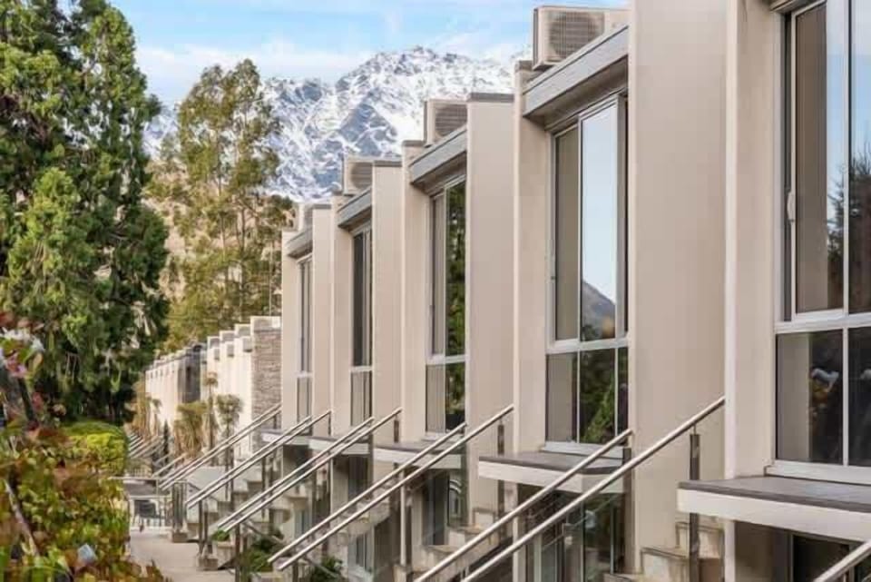 Modern apartment complex set against a stunning alpine backdrop.