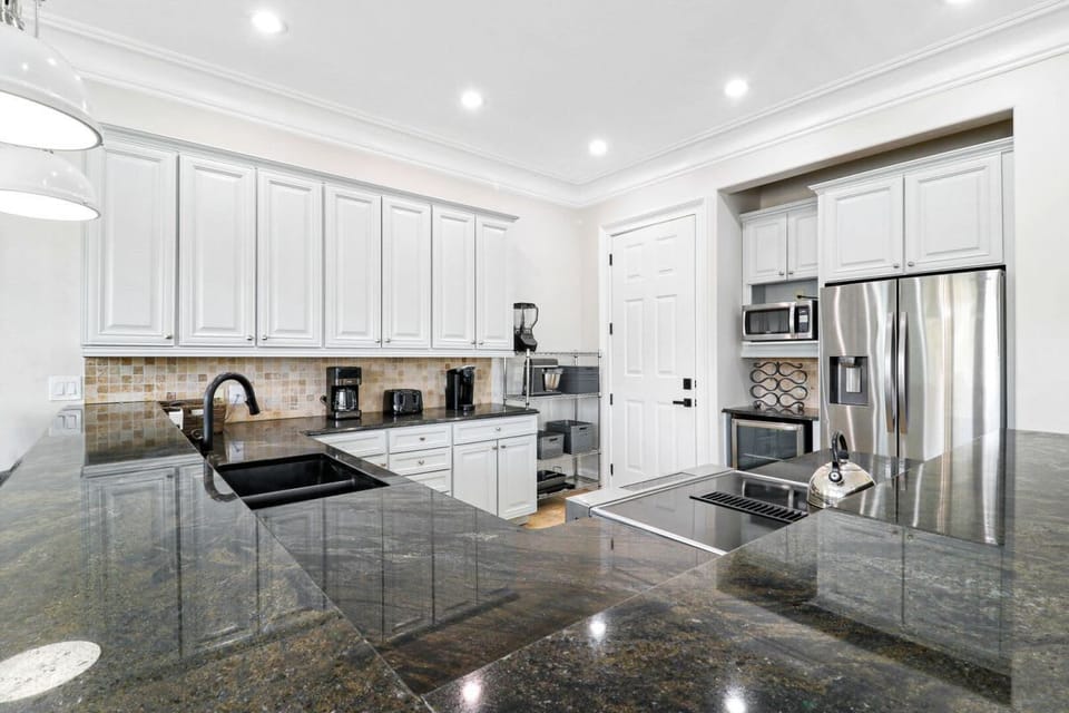 Modern kitchen with dark granite countertops and white cabinetry
