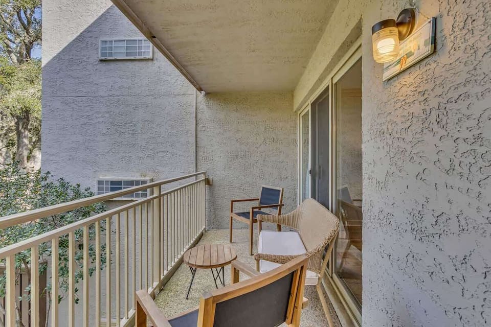 Relax on the cozy balcony with seating and a small table for outdoor enjoyment.