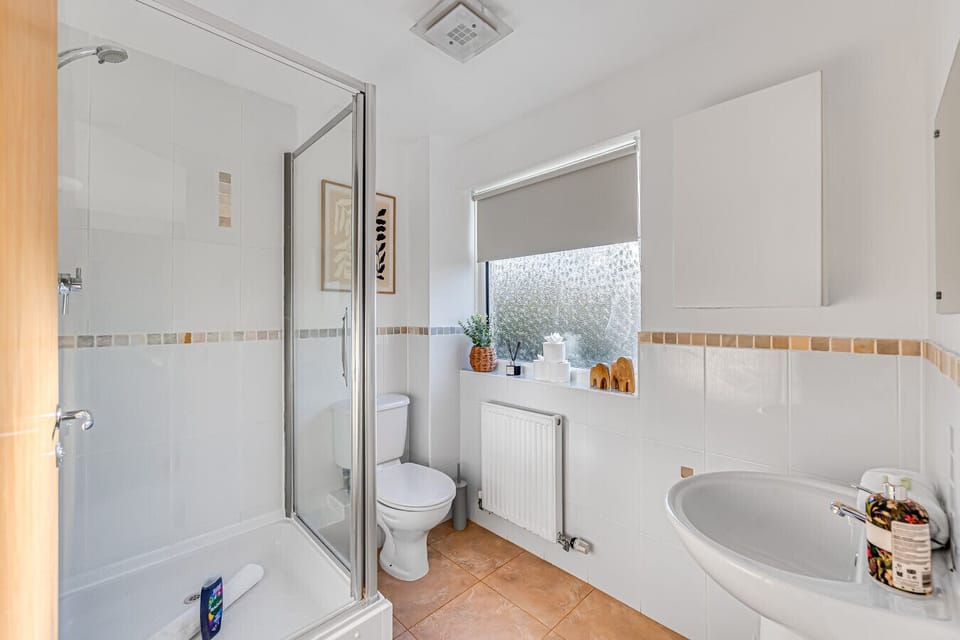 Bedroom one features an en-suite shower room, complete with complimentary toiletries.