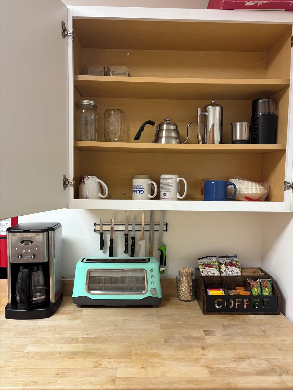 Coffee and tea station with coffee maker, french press, grinder, and tea kettle.