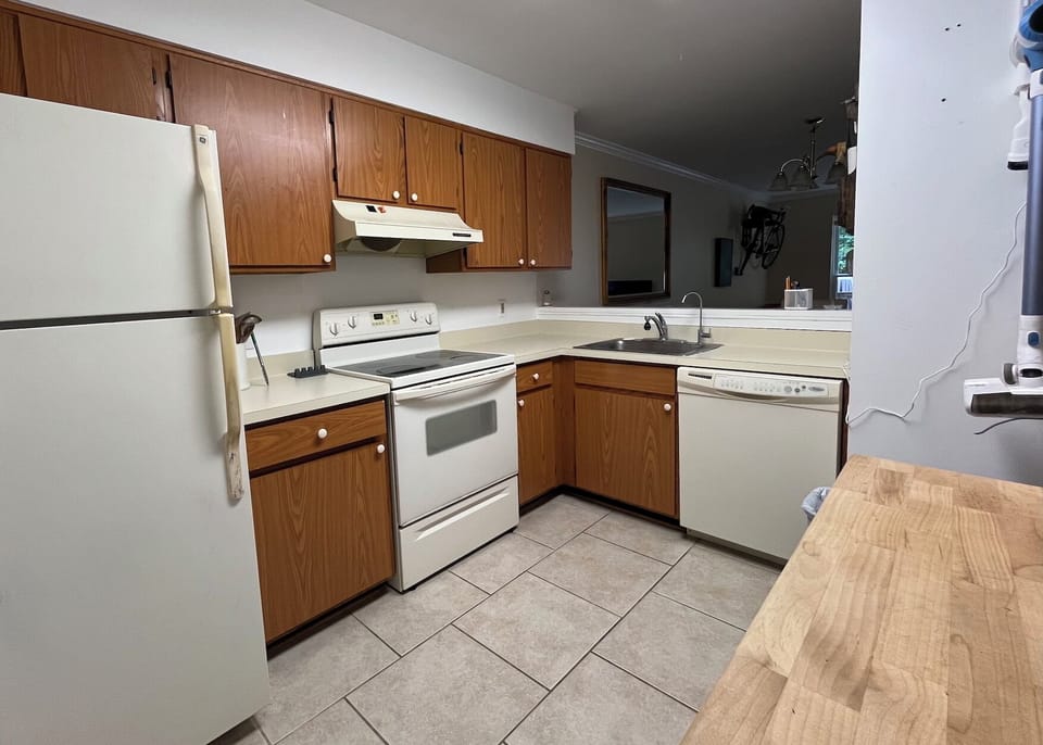 Full kitchen stocked with glasses, plates, utensils, and cooking essentials.