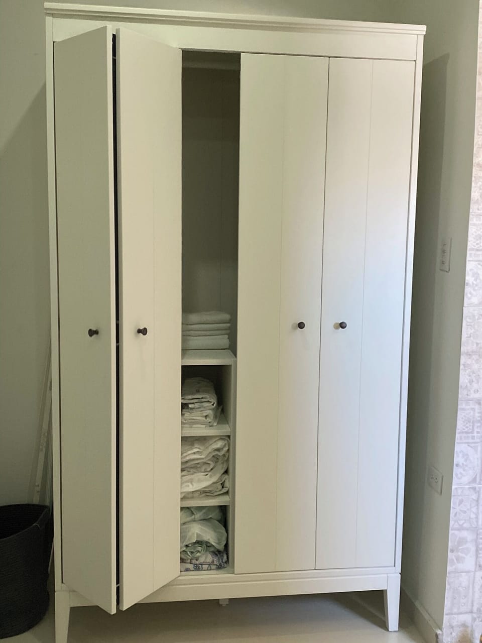 Armoire with linens, iron and storage