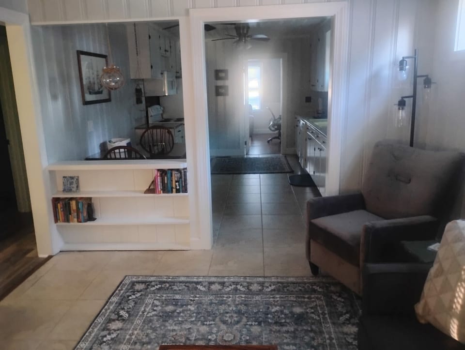 Back living room with futon (opens to full sized bed) looking toward kitchen. 