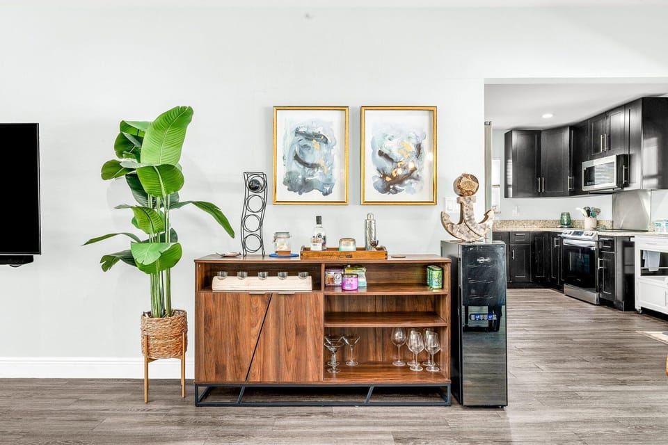 Stylish accent area with modern credenza, greenery, and artwork - adds a warm, contemporary touch as you transition toward your kitchen