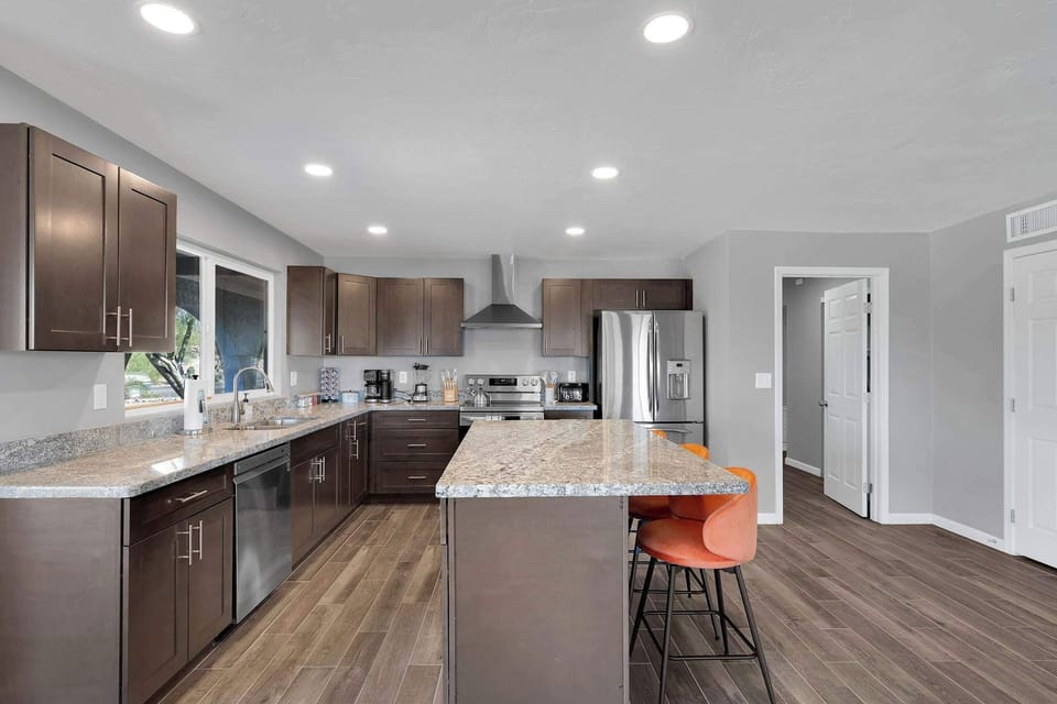 Dine in style at this elegant, minimalist table set beneath warm lighting. The open layout connects seamlessly to the living space, creating a relaxed and social atmosphere.