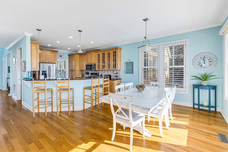 Dining table with seating for six, a breakfast bar for four, and an open kitchen.