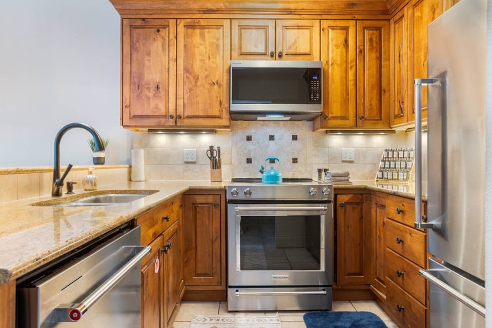 Fully equipped kitchen with modern appliances and warm wood cabinetry—great for cooking at home.