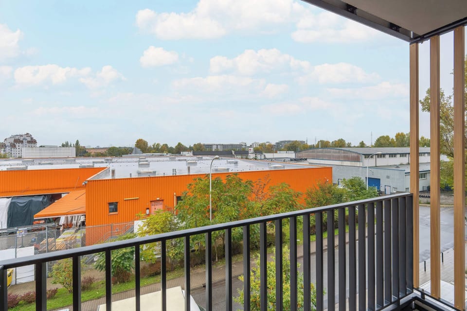 The balcony view over rooftops and greenery lets you experience the peaceful atmosphere of the city.