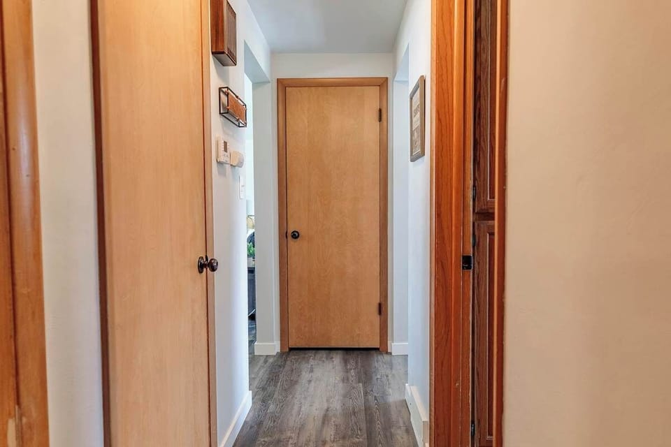 A bright hallway leading from the bedroom at the end, opening up into the spacious living room and kitchen—creating an inviting flow throughout the home.