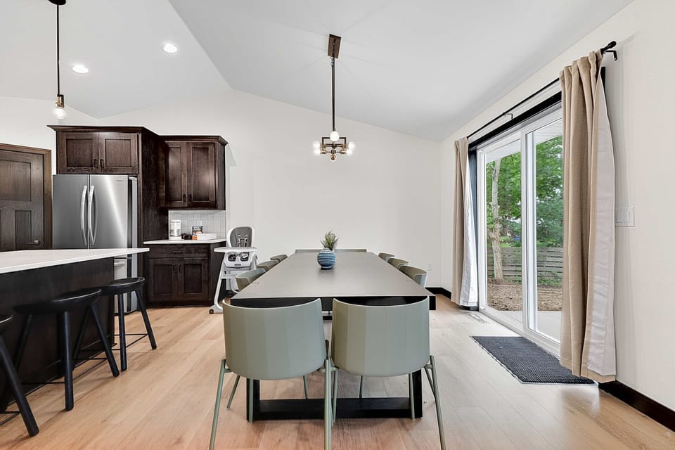 Gather around the spacious dining table that seats 10—perfect for group meals or game day feasts. Patio doors open to the backyard for indoor-outdoor entertaining at this modern home just 3 houses from Lambeau Field in Green Bay.