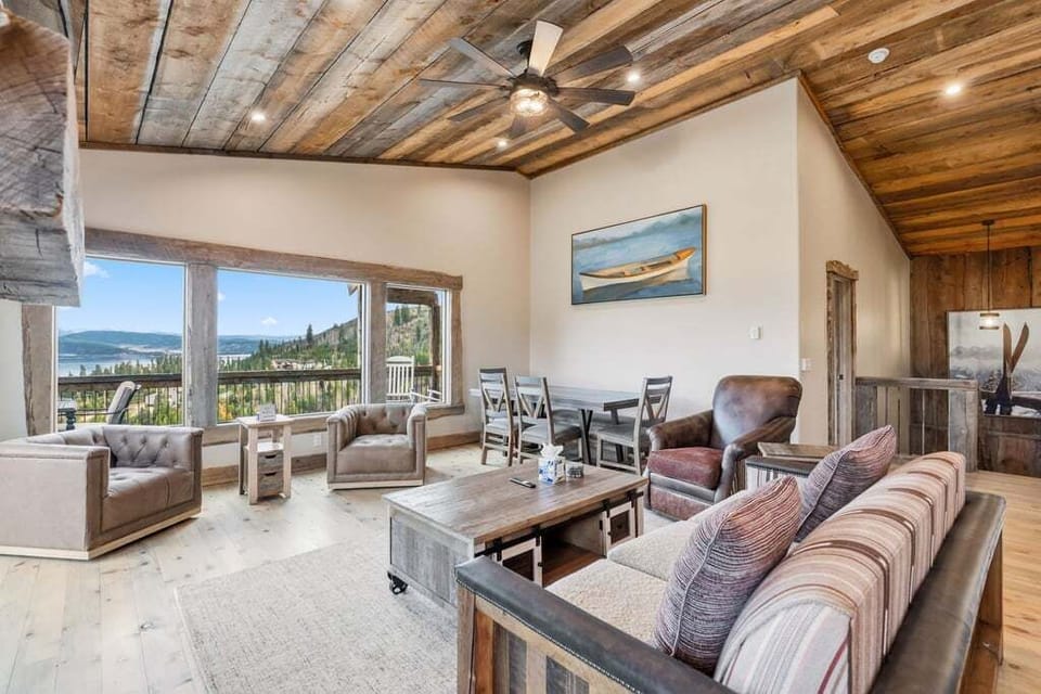 Your spacious living area features rustic wood beam ceilings, comfortable seating, and stunning panoramic views through expansive windows.
