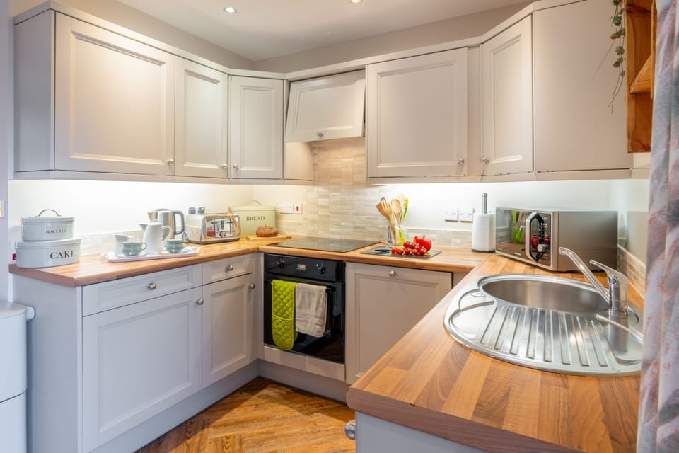 Ground floor: Kitchen with an integrated oven and electric hob, under counter fridge with icebox, microwave, dishwasher and washer/dryer