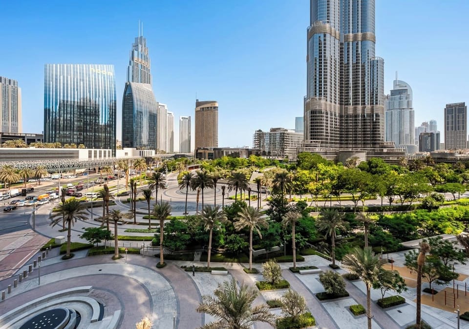 Panoramic Dubai skyline where soaring towers meet lush green landscapes.