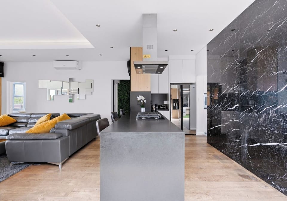 Kitchen island seating flows into a lounge with a generous sofa and wall art