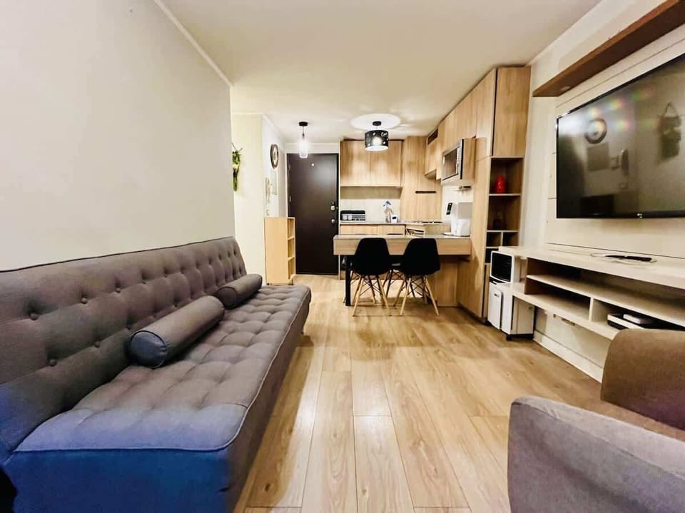 Bright living room w/ plush sofa, TV & warm wood floors for relaxed evenings in