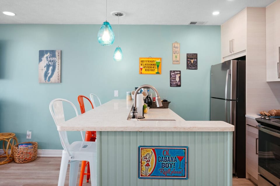A full view of the inviting kitchen island featuring a playful `Cabana Boy` sign and soft teal walls. 🏖️💙