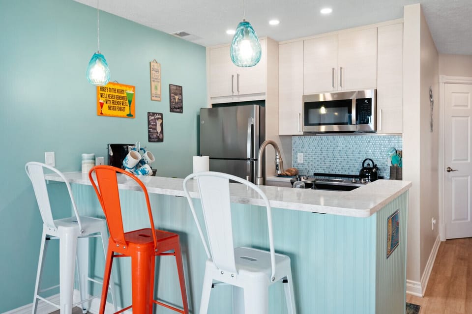 The perfect blend of modern appliances and cheerful coastal decor in a compact, well-lit kitchen space. 🍳☀️