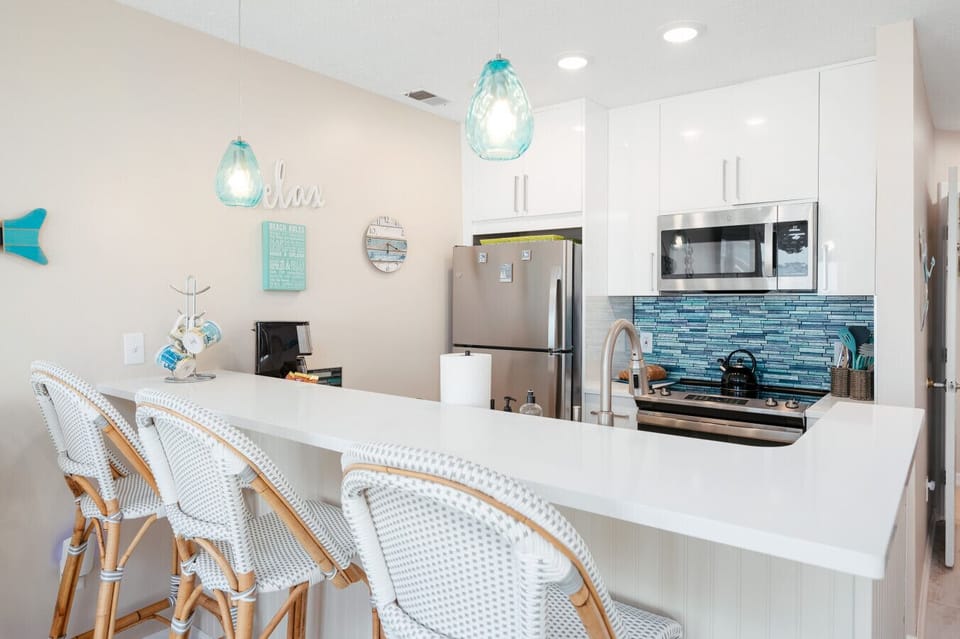 Pull up a seat at the breakfast bar where modern style meets beachy charm—the perfect spot for a quick bite or evening cocktail. 🍸⛵