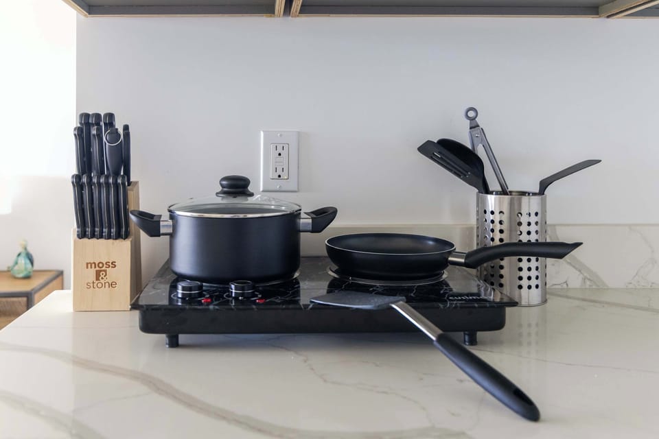 Prepare delicious home-cooked meals with ease using a portable cooktop fully stocked with cookware, utensils, and a knife block set.