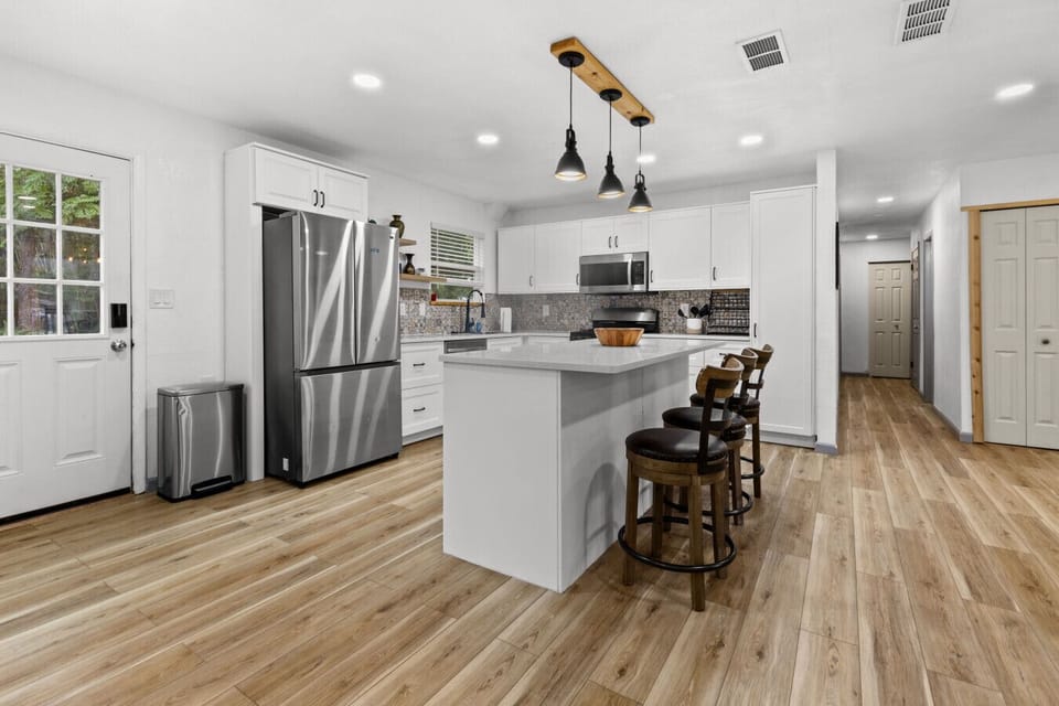 Bright, fully equipped kitchen with stainless-steel appliances and a spacious island for cooking or gathering.