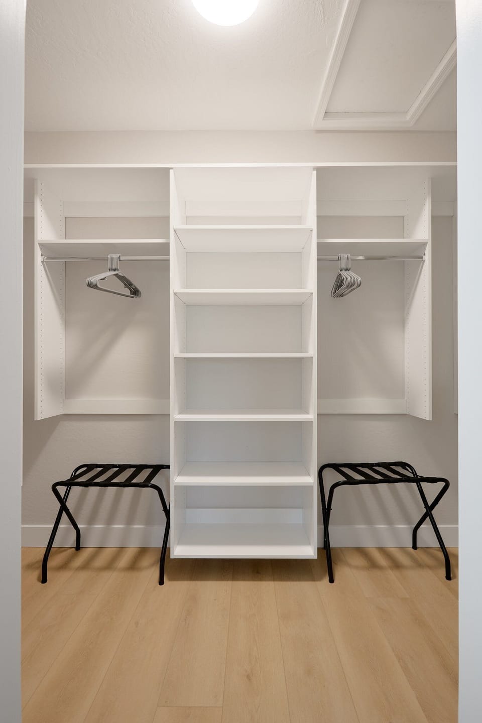 Inviting primary bedroom with a King bed, cozy seating, walk-in closet, en-suite bathroom, and private balcony, creating a serene retreat with warm, natural tones.