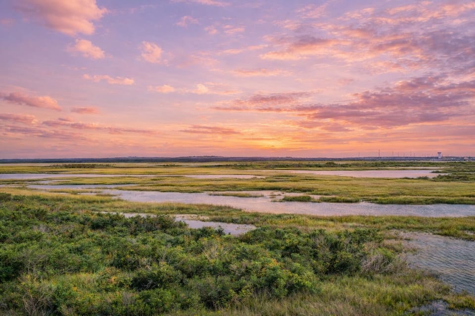 Stunning coastal marshland and sunset views near Galveston Beach, highlighting the natural beauty surrounding the Bay Breeze Drive vacation home.