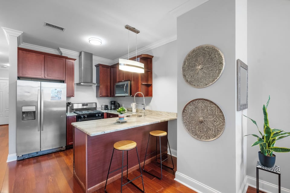 Fully-equipped kitchen with cherry wood cabinets, stainless appliances, and granite counters ideal for preparing home-cooked meals.