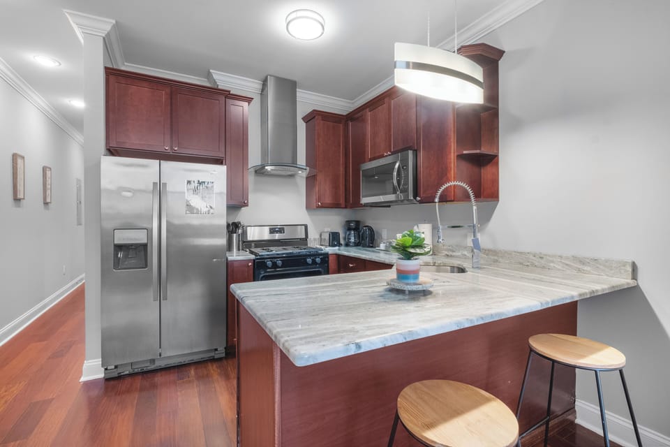 Kitchen workspace with stainless refrigerator, gas range, and ample counter space for meal preparation.